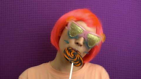 Beautiful stylish girl is eating lollipop.