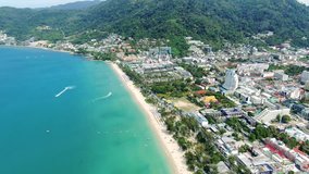 Aerial video footage of sunny Patong Beach in Thailand, Phuket, showing the entire city landscape view from the drone.
