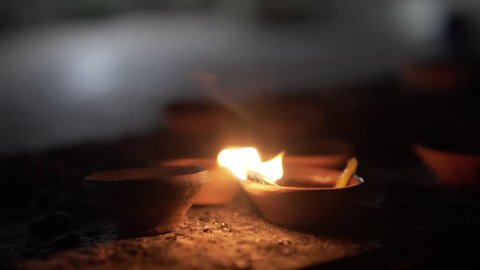 Traditional Indian lamps lit at night. Deepak Oil lamp. During Diwali. Slow motion.
