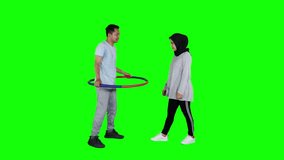 Happy young couple playing hula hoop in the studio. Shot in 4k resolution with green screen background - Powered by Shutterstock - Get 15% off with code: PIKWIZARD15