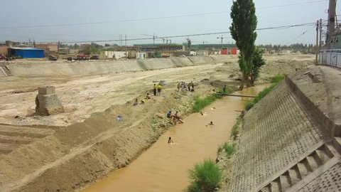 Kuqa Xinjiang Children Playing and Swimming at Sandy Muddy Colored Kuche River