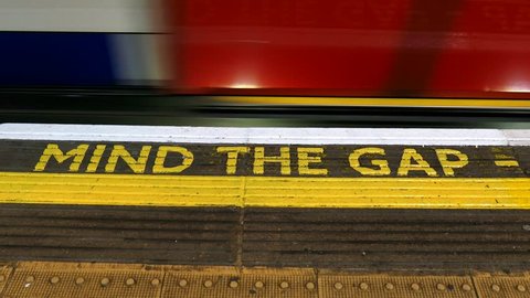 Mind The Gap Sign in London Tube Station and Passing Trains