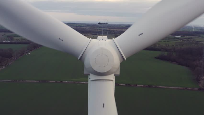 Close up of a wind turbine spinning over farmers fields during sunset. | Shutterstock HD Video #1021640293