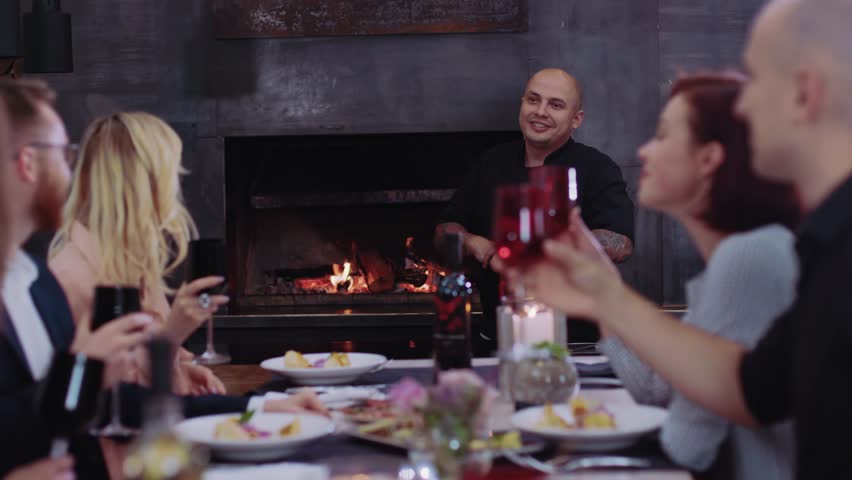 Happy young chef talking to customers at cozy restaurant communication woman man conversation eat work celebrate discussion enjoy guys close up slow motion Royalty-Free Stock Footage #1021644700