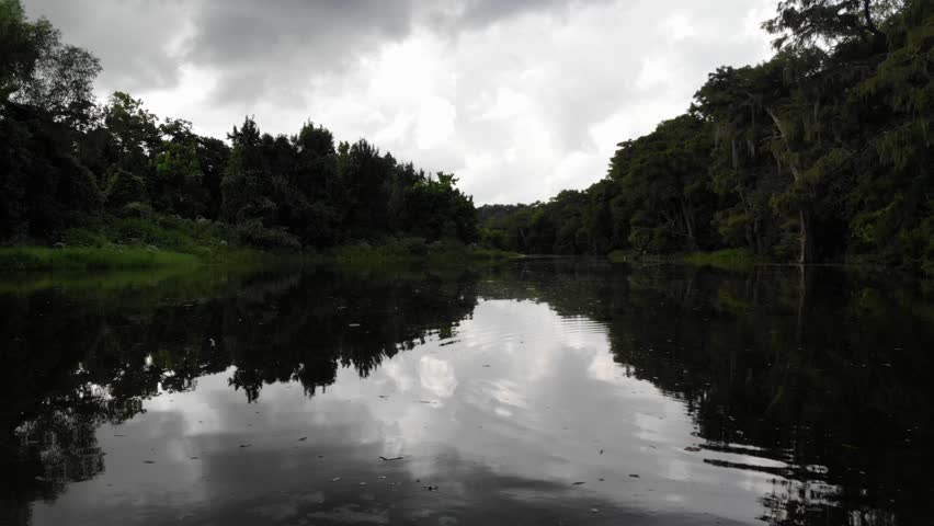 Close to water Drone footage flying down the San Jacinto River with sky and clouds reflections.
