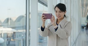 Businesswoman take photo on cellphone in the airport