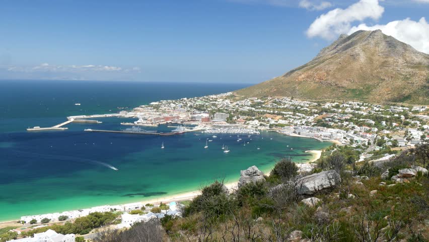 Elevated wide angle view of Simonstown, Naval base, mountain, houses, boats & beaches with blue ocean skyline