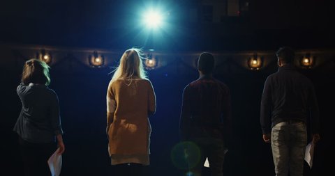 Slow motion of actors and actresses bowing to audience in a theater