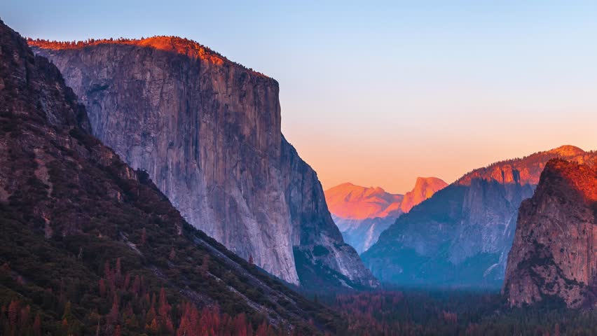 Yosemite National Park Tunnel View overlook at sunset. Front view panorama of popular El Capitan and Half Dome at deep red sunset. Summer american holidays. California, United States.