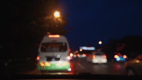 Blurred footage of rainy night scene in car overlooking busy road or highway, travel, long journey, holiday trip. 