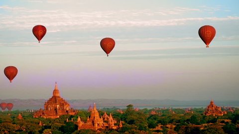 BAGAN, MYANMAR - DEC 21, 2014: Hot air balloons flying at sunrise over ancient Buddhist Temples at Bagan. Myanmar (Burma) travel landscape and destinations