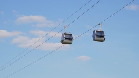 Two funicular cabins slowly moving in the air