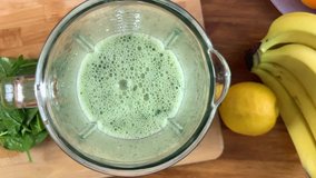 Blender with green detox smoothies: spinach, bananas. Slow motion video