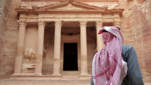 Bedouin man stand infront the Jordan Petra Facade Of The Treasury Building The Ancient Nabatean. Petra is a famous archaeological site in Jordan's southwestern desert.