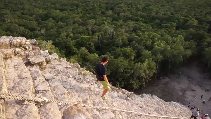 Young Male walking down the steep steps at the Coba Maya Ruin in the Yucatan Peninsula of Mexico.