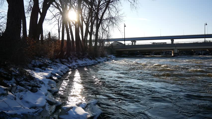 Near the water of the Fox River in Appleton, Wisconsin during the day with the city in the background.