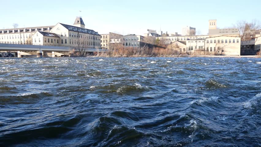Near the water of the Fox River in Appleton, Wisconsin during the day with the city in the background.