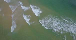 Aerial view beautiful of sand, sea waves from drone. Stock video footage of blue ocean water, wave, sea surface. Top view on turquoise waves, clear water surface texture. Aerial view, amazing nature