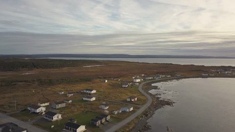 Aerial panoramic view of a small town on a rocky Atlantic Ocean Coast during a cloudy day. Taken in Raleigh, Newfoundland, Canada.
