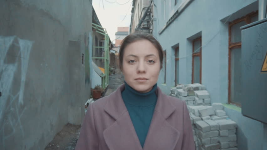 The girl in the purple coat is looking at the camera. Parallax effect. Slow motion.