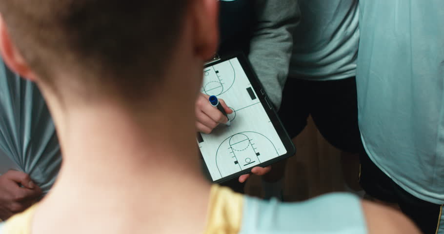 CU view of basketball coach using his tablet to explain combination to a team. 4K UHD Royalty-Free Stock Footage #1021717033