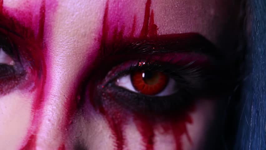 The girl in the form of a demon. Red eyes close up. | Shutterstock HD Video #1021717690