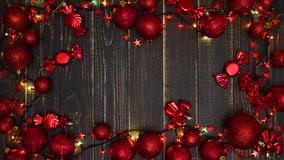 Beautiful red noel Christmas holdiay frame isolated on brown wooden background. Place for text in center between Xmas ball and decorations. Real time 4k video footage.
