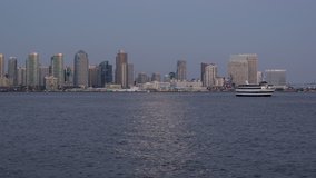 San Diego City Skyline Twilight Moonrise Time Lapse - Time lapse video of moon rising over San Diego Bay at twilight with downtown cityscape and passing boats