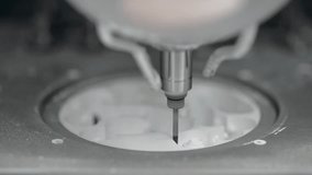 Very closeup video recording of a hi-speed spindle of a dental milling machine which carving out shape of human teeth on a ceramics zirconia disc.