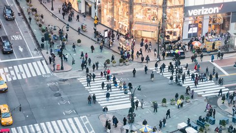 New York City, USA - April 6, 2018: Timelapse, time lapse of high angle, aerial view of building in NYC Herald Square midtown with crowd of people crossing crosswalk, Verizon and H&M store at night