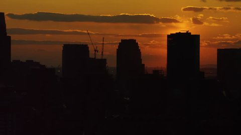 Shot on 4k RED camera on helicopter. Aerial view of silhouettes of buildings and skyscrapers in downtown Manhattan, New York City with soft sunset sky.