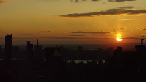 Aerial view of silhouettes of buildings and skyscrapers in downtown Manhattan, New York City with soft sunset sky. Shot on 4k RED camera on helicopter. 