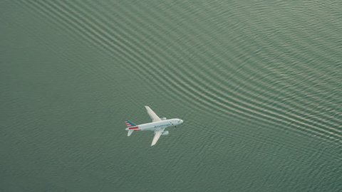 New York City, United States of America CIRCA 2018 - A commercial airplane flying over water and landing in New York City on a sunny day. Shot on 4k RED camera on helicopter.