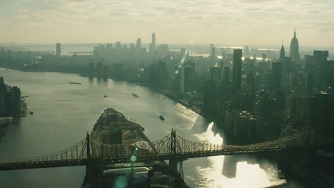 Aerial view of Manhattan skyline skyscrapers from river and the Queensboro Bridge in New York during the day under blue skies. Wide shot on 4K RED camera.