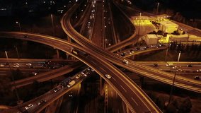 Aerial drone high speed night video of urban elevated road junction and interchange overpass in city with light traffic