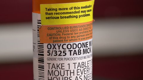 MORGANTOWN, WV - JANUARY 2, 2019: Rotating macro of Oxycodone prescription bottle with USA flag in background