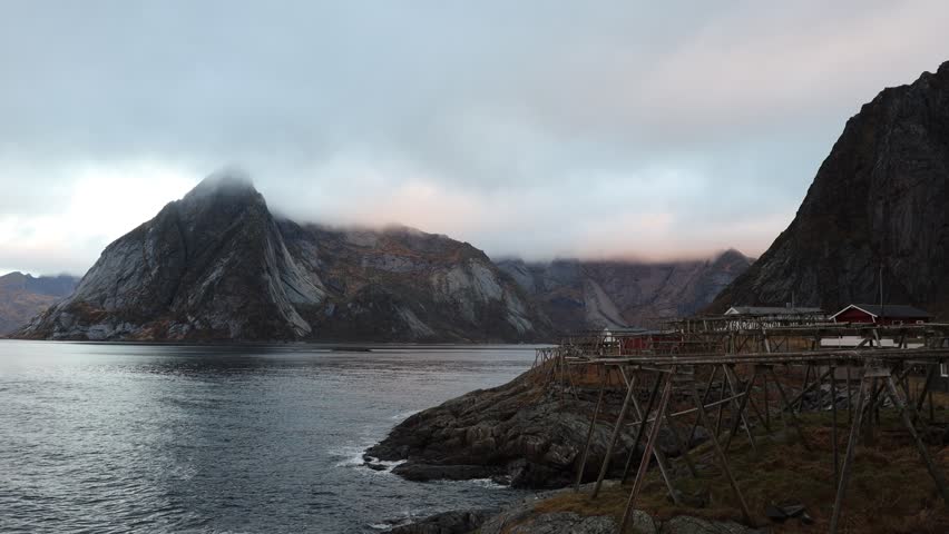 Time lapse Hamnoy fishing village with red rorbuer in the morning with rain and fog at Lofoten islands, Norway