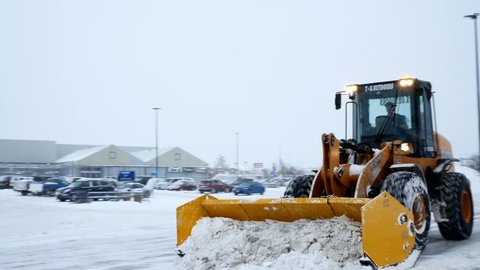 BEMIDJI, MN - DEC 27, 2018: Snow removal machines clearing Walmart parking lot during storm.