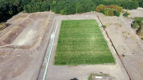 Amazing bird`s eye view of a rectangular football field with mowed grass surrounded with country lanes in Askania-Nova on a sunny day