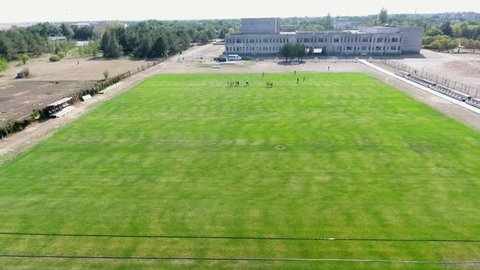 Lovely bird`s eye view of a tidy football field with mowed grass surrounded with plowed territory in Askania-Nova on a sunny day
