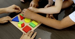 Colse up scene video of Asian teacher play geometry blocks toy with Asian student together, concept for classroom.
