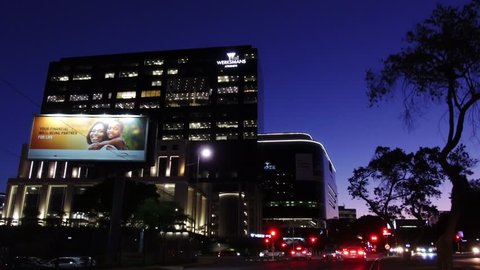 Johannesburg, South Africa, 11 December - 2018: Modern African city at evening time. Camera moves along road away from buildings.