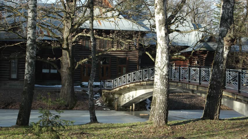 Alleys, bridge and frozen lake in a city park on a sunny winter day