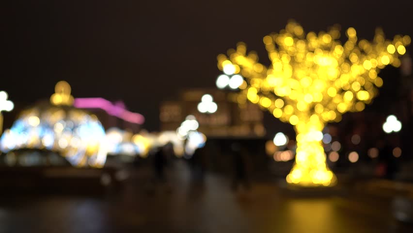 Deliberately blurred image of people walking around the festive city. Christmas lights. Christmas mood in the city.
