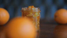 Closeup. Cup Of Orange Jam And Oranges On The Wooden Table. HD Video Footage. Beautiful Background.