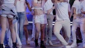 Footage of a crowd or group of young, stylish multi-ethnic people during party in white clothes . Break dancer having fun dancing at a white party . Shot on RED HELIUM Cinema Camera in slow motion.
