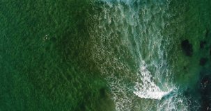 Aerial view of a surfer paddling out at the Guincho Beach, in Cascais, Portugal
