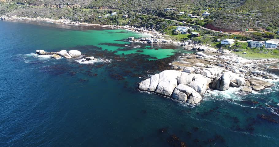 Aerial view of a holiday beach town with boulders and clear water in Cape Town South Africa