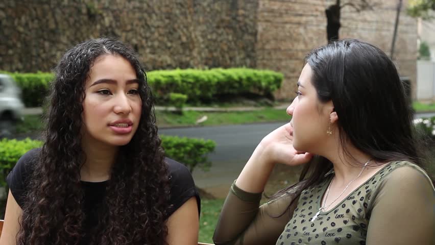 Cali, Colombia - June 25, 2018: Girls speak sitting down on bench in park 3