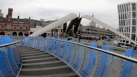 Coventry, West Midlands, UK - December 31, 2018: Hyper lapse across Millennium glass bridge in Coventry city centre going towards transport museum on a cloudy winter day